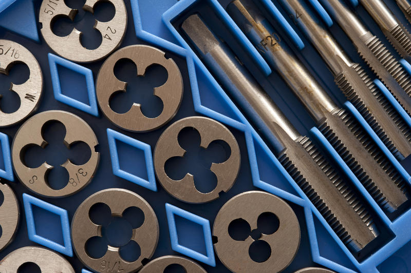 Tap and die set in blue packaging for manufacturing threads on screws