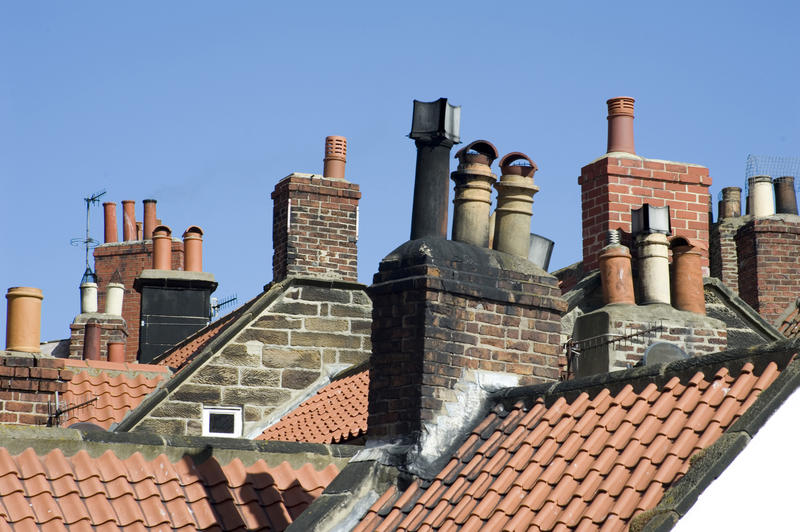 A view across tiled rooftops showing the roof details with chimney stacks and pots