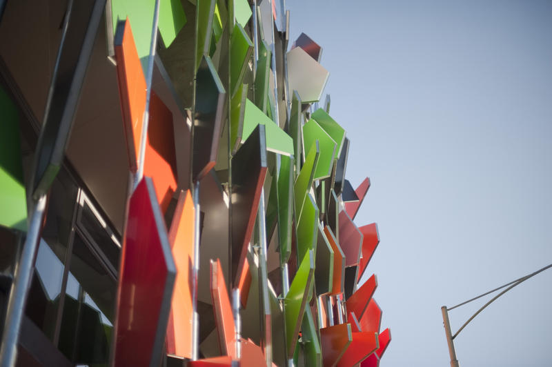 Colourful panels on an external building facade in a modern building design, viewed from below against a blue sky
