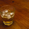 10631   Glass of Cold Whiskey with Ice on Wooden Table