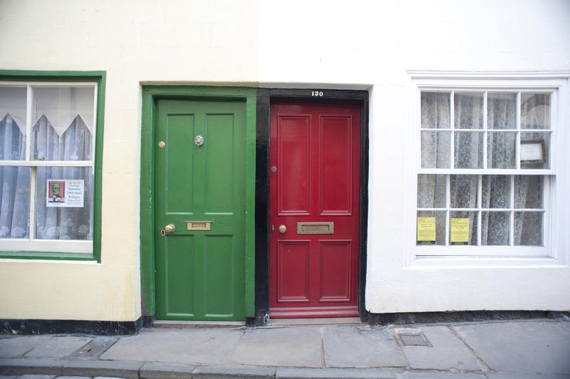 The coloufrul front doors of Caedmon Cottages in Church street in Whitby which are holiday rental premises