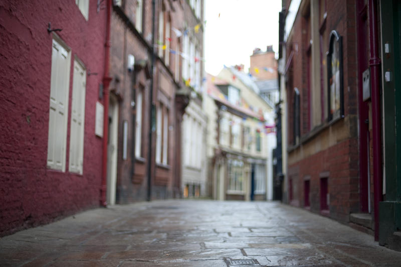 Low angle view of the cobblestones looking down Grape Lane in Whitby lined with traditional old English architecture