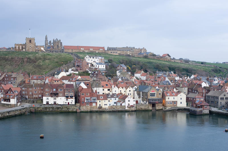 High angle view looking down over the lower harbour at Whitby towards Tate Hill and the ruins of Whitby Abbey
