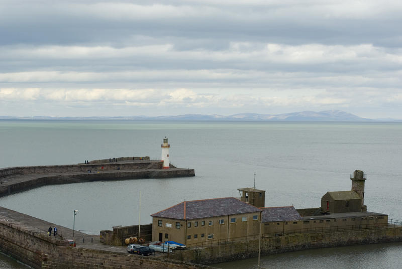 View of Whitehaven harbour and its lighthouse at Whitehaven, Cumbria, England under a cloudy sky