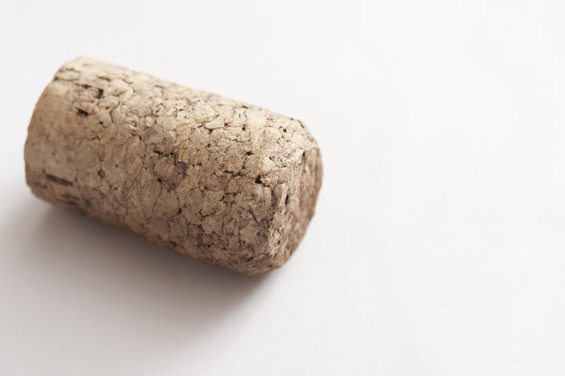 Close-up of brown cork from wine bottle on white table.