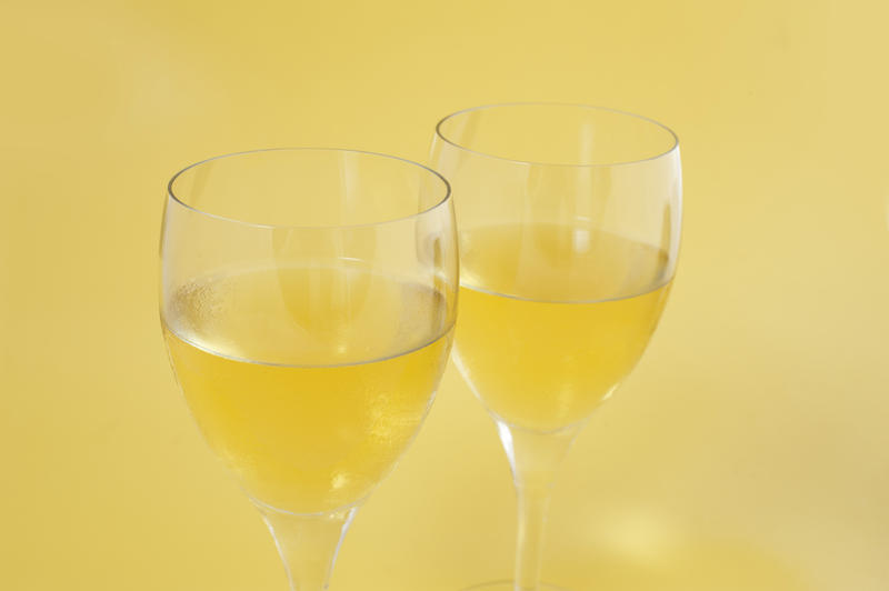 Two glasses of wine wine on a pale yellow background as an aperitif or accompaniment to a meal