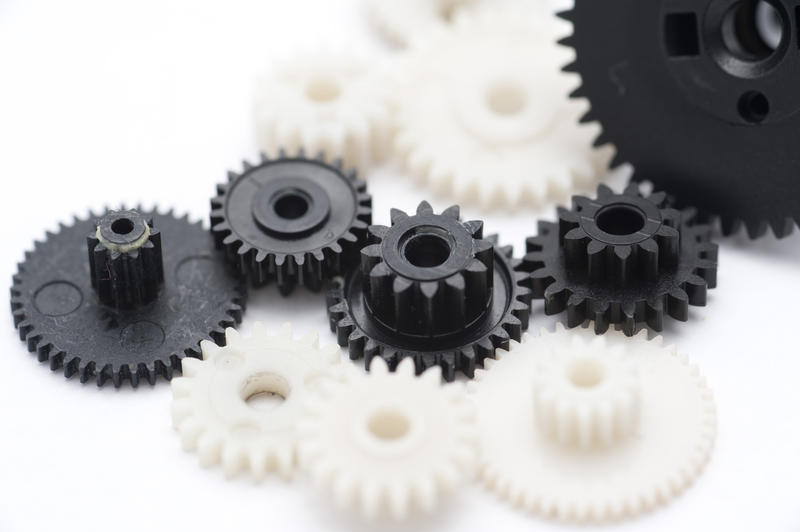 Working Together Concept - Close up Black and White Plastic Gear Wheels Isolated on White.