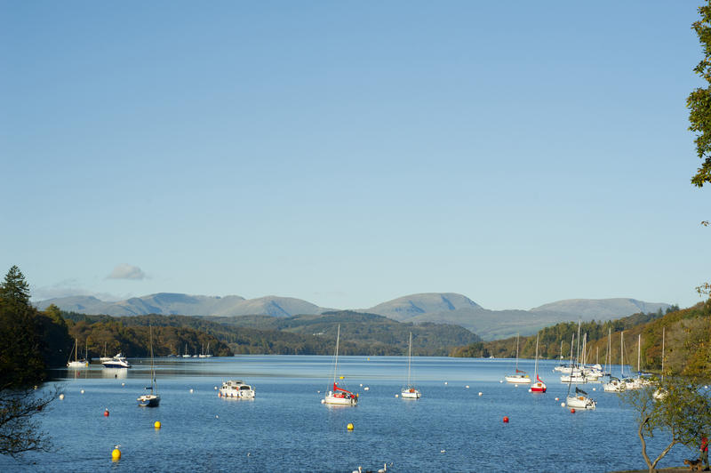Tranquil view of yachts moored on Windermere Lake in the English Lake district in Cumbria against a mountain backdrop