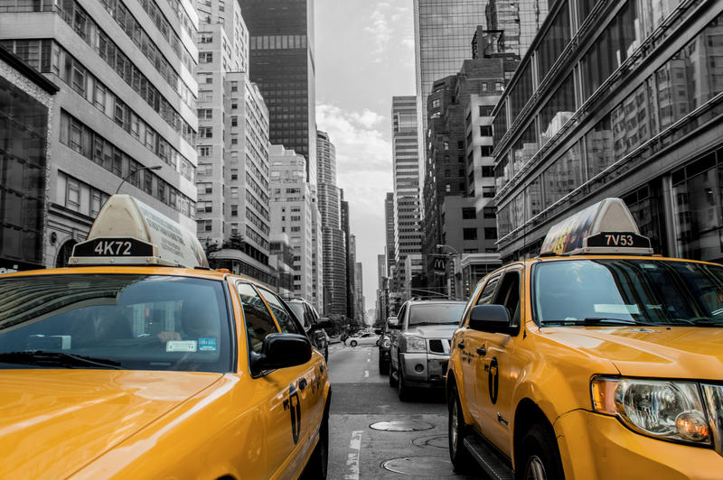 <p>Two yellow cabs in the foreground, with background turned to black and white.</p>
