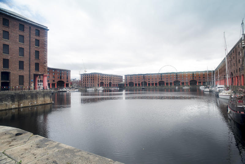 Wide open harbor surrounded by multi-story brick warehouse buildings at Liverpool Albert Dock in the United Kingdom