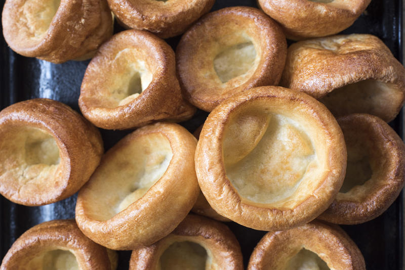 Background texture of individual golden puffy Yorkshire puddings fresh from the oven ready to be served with a roast meat dinner