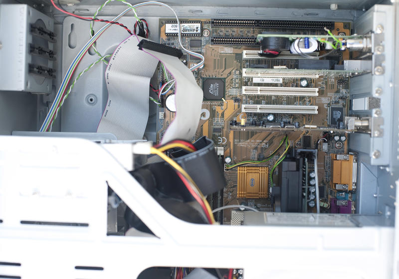 Motherboard installed inside big computer box, close-up image with case metal elements in foreground