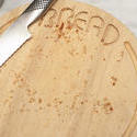 17149   Circular wooden bread board with crumbs and knife