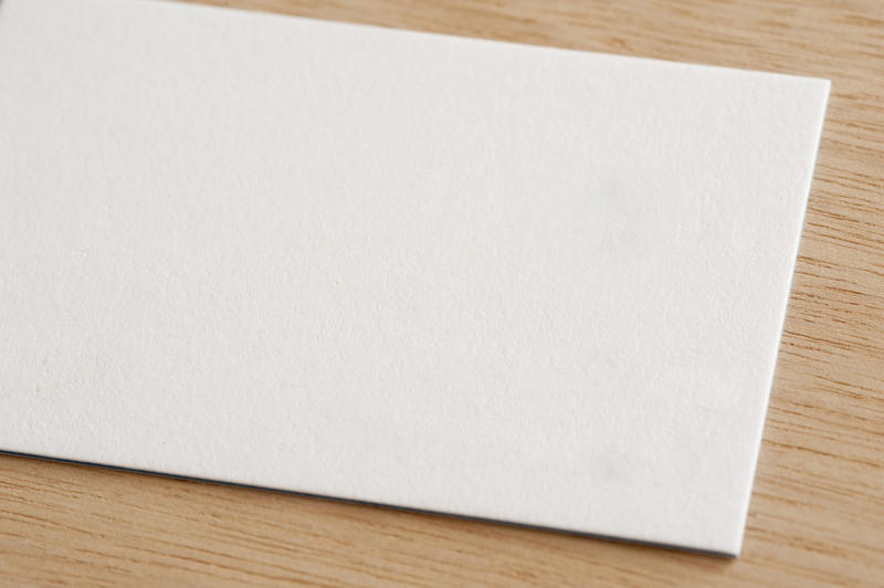 Close up on half of white envelope with copy space over light brown wooden table