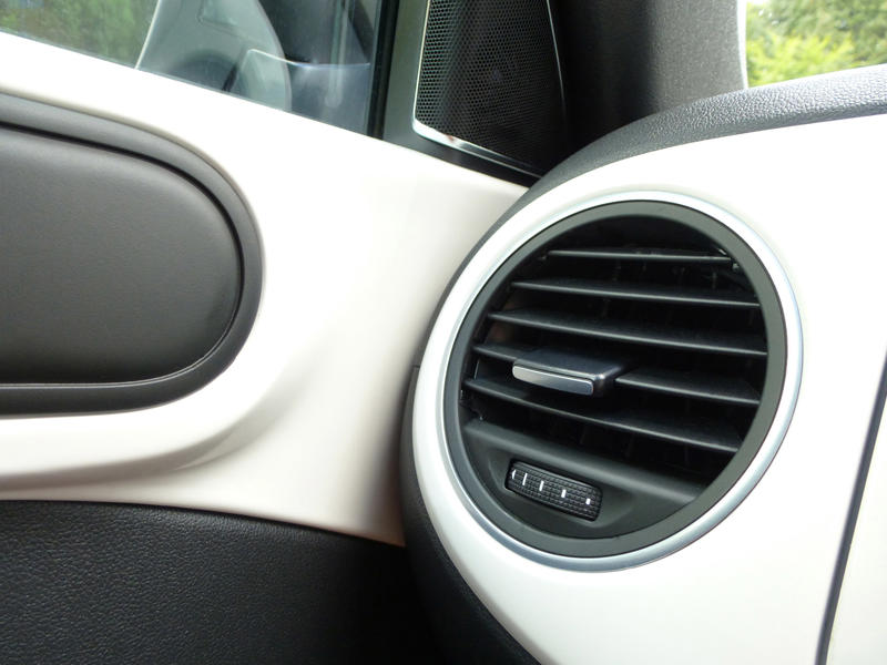 Black side air vent in a white motor car viewed into the corner angle with the door in a travel and transport concept