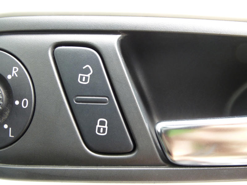 Car window control buttons showing open and closed padlock icons for safeguarding children