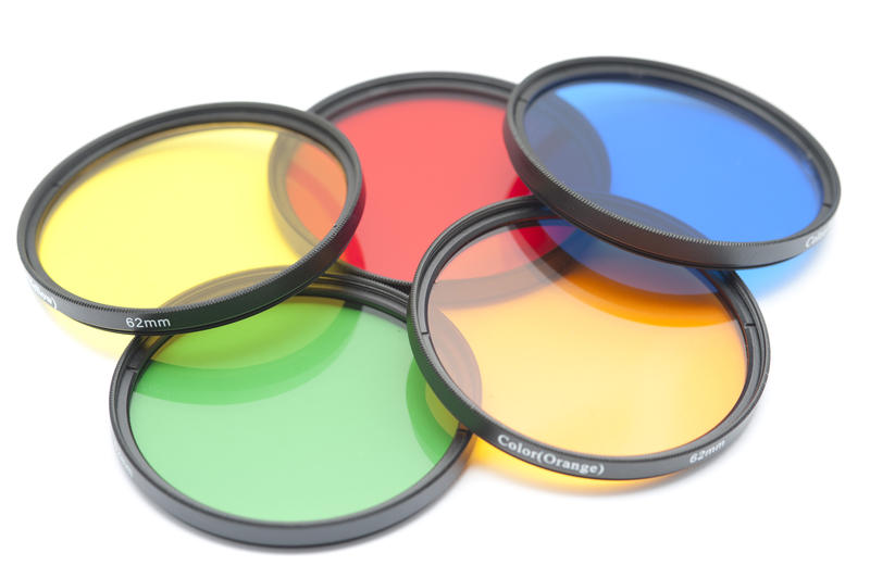 Close up on a set of five isolated color contrast photography lenses in yellow, red, blue, green and orange