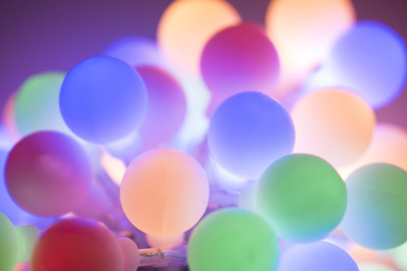 Colorful cluster of round pastel Christmas lights glowing softly in a full frame festive holiday background