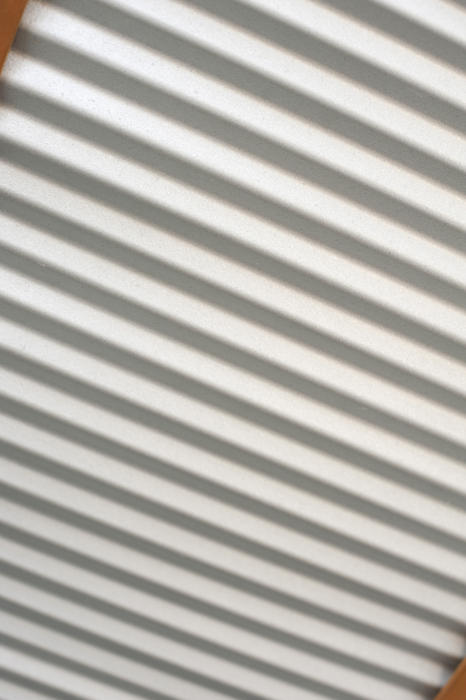 Corrugated metal sheeting with diagonal lines in a tilted view of cladding, a shutter or door in a full frame background texture and pattern
