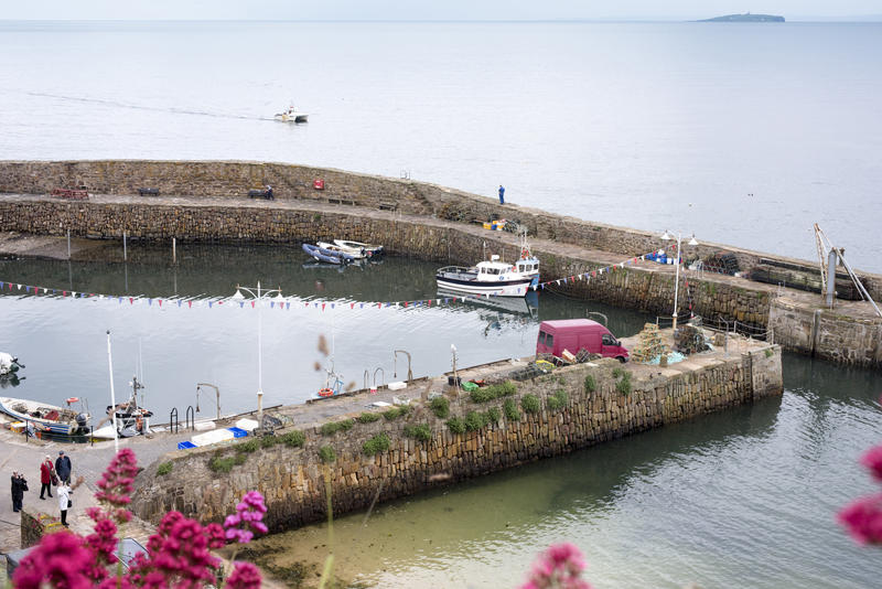 High angle view of the picturesque tranquil stone harbour, Crail, Fife Coast, Scotland with a few moored fishing boats against the pier