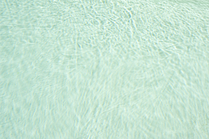 Shadows from waves on water at bottom of pool as abstract textured background with copy space for calm theme