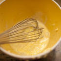 12997   Overhead view of eggs in mixing bowl with whisk