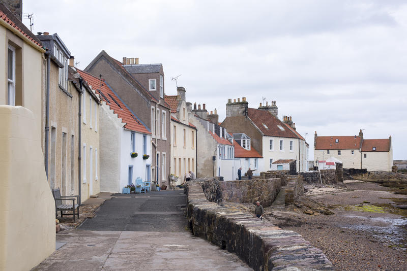 Rows of two story houses and narrow lane during low tide at Pittenweem coast in Scotland