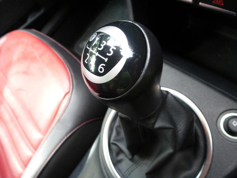 Crop close up black leather manual transmission selection lever in modern car.