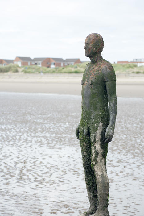 Cast iron figure from Another Place by Anton Gormley on Crosby Beach, UK