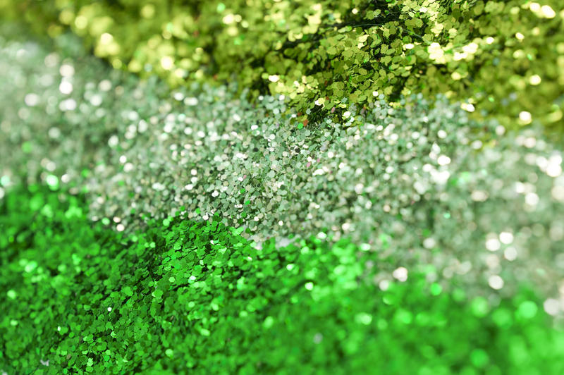 a background with three colours of green glitter in rows