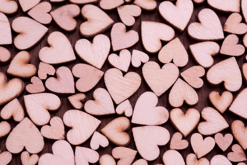 Valentines background pattern of pink hearts on wood in a random arrangement full frame view conceptual of love and romance