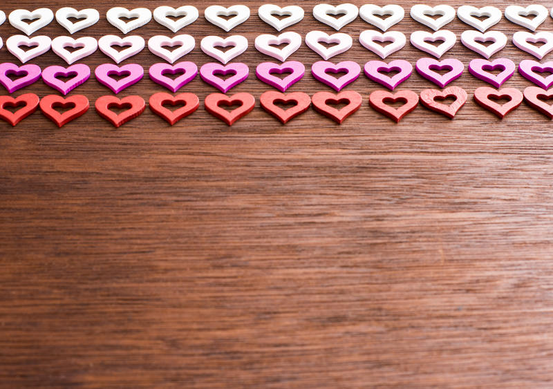 a wooden surface with colourful red and pink hearts