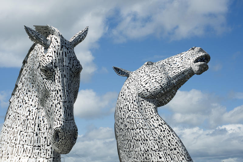 The Kelpies, Falkirk, Scotland against a blue sky a sculpture of two horses heads commemorating their role in industry