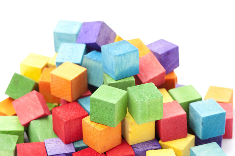 Jumbled Pile of Colorful Wooden Toy Blocks in Childhood Concept Image in Studio with White Background and Copy Space