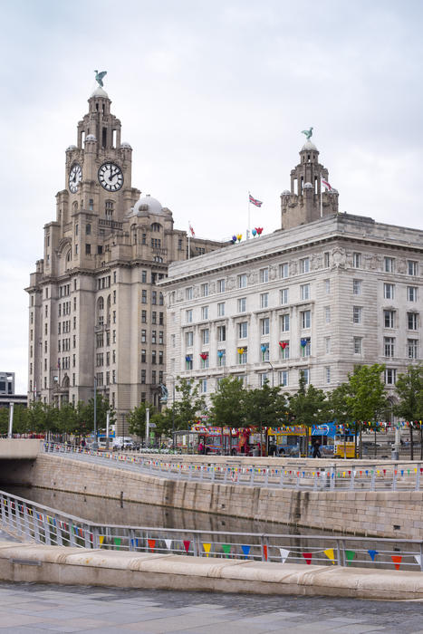 Architectural Skyline View of Royal Liver Building and Historical Clock Tower at Liverpool Waterfront, England, UK on Overcast Day