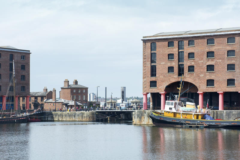 Calm waters and yellow tugboat at Liverpool Albert Dock in the United Kingdom, Europe
