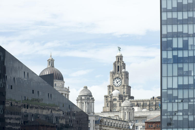Modern and historic architecture, Liverpool, UK with a view past a skyscraper to the clock tower of the Liverpool building in the distance