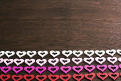 13105   Four lines of colorfully shaped hearts over wood