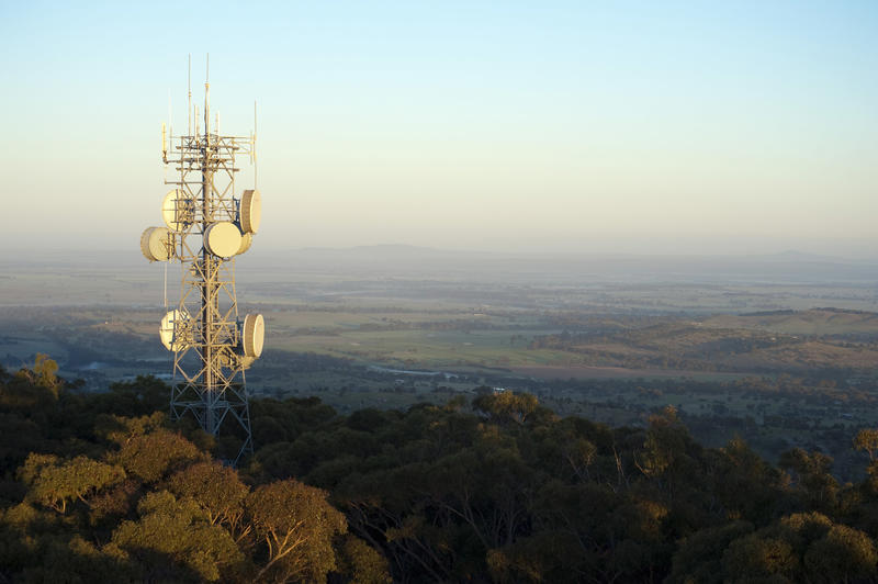 Mobile phone mast on a hilltop with dish antennae and transmitters in a communications concept, copy space to the side