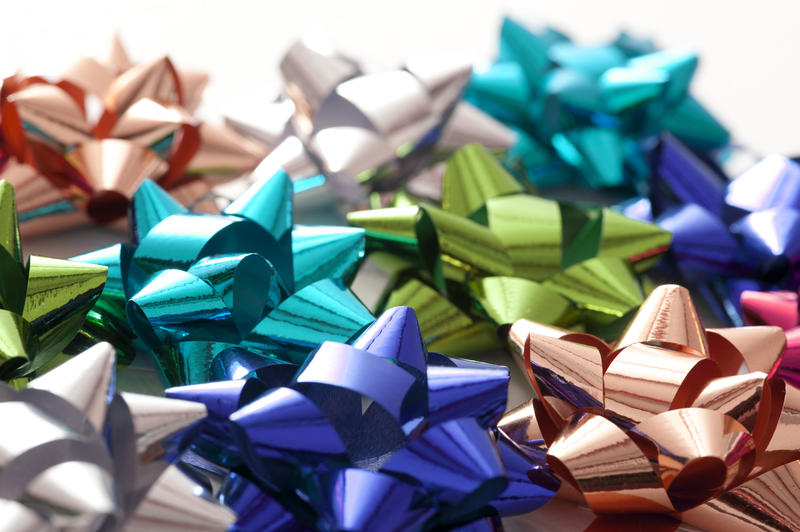 Full Frame Background of Colorful Metallic Gift Bows Scattered on White Background with Copy Space