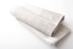 12735   Folded newspapers over neutral color background