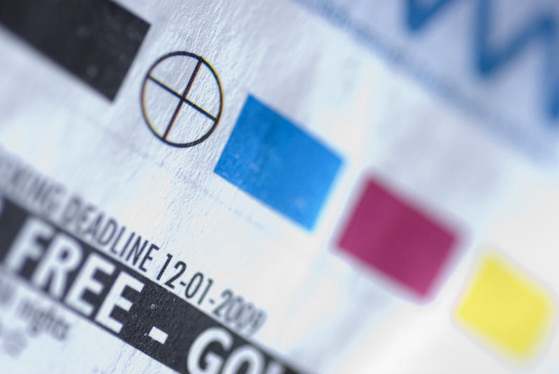 Selective focus extreme close up on printer registration mark and color swatches on paper