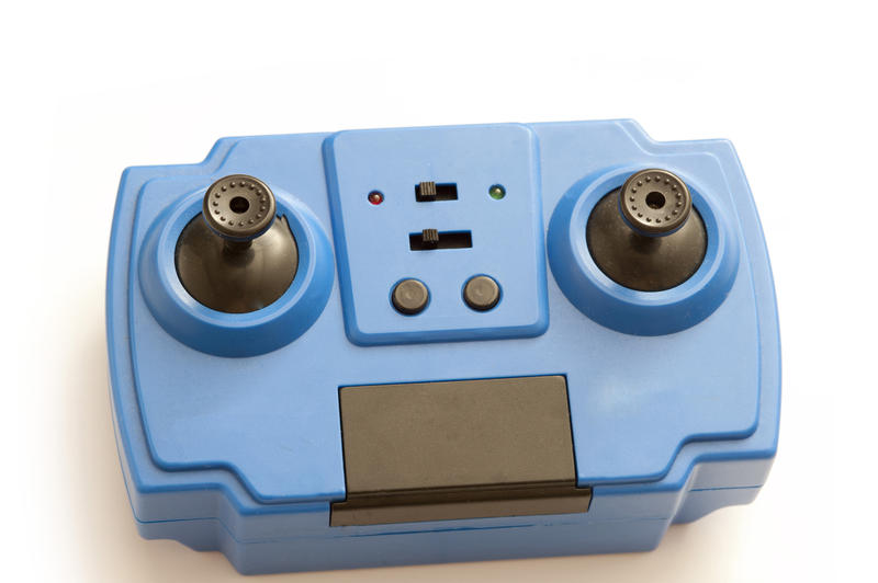 Small blue electronic gaming control for kids with directional toggles for playing video games over white