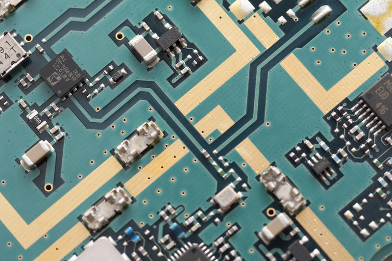 Diagonal top down view on printed circuit board with transistors and capacitors as technology theme background with copy space