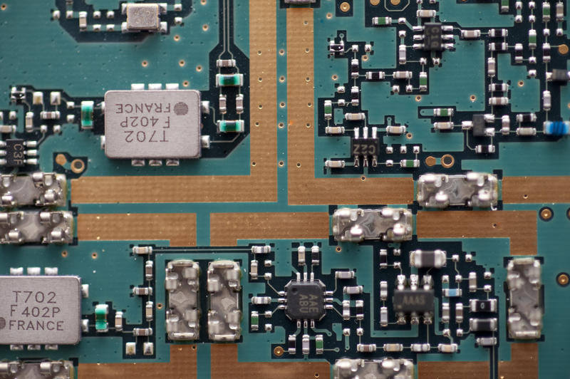 Close up on printed circuit board of transistors, capacitors and other components with copy space in the center