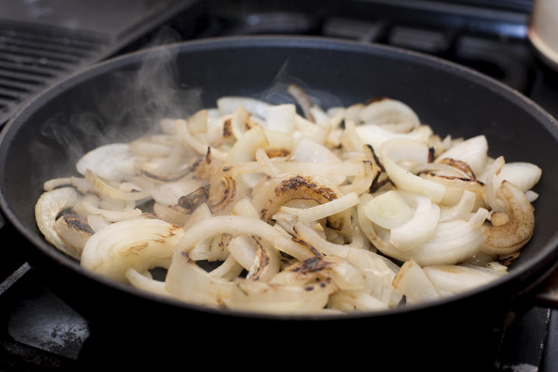 Diced onions sauteing in a frying pan to soften them ready to be added to a recipe as a cooking ingredient