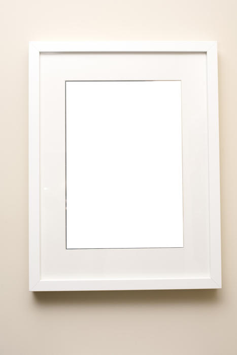 Simple empty white picture frame with off white mount card around central copy space on a neutral beige cream background