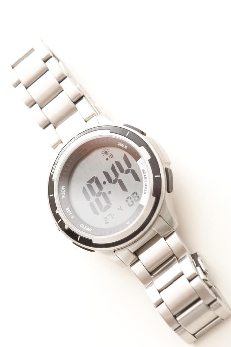 Gents sports wrist watch with a stainless steel bracelet strap viewed from above in a diagonal orientation on white