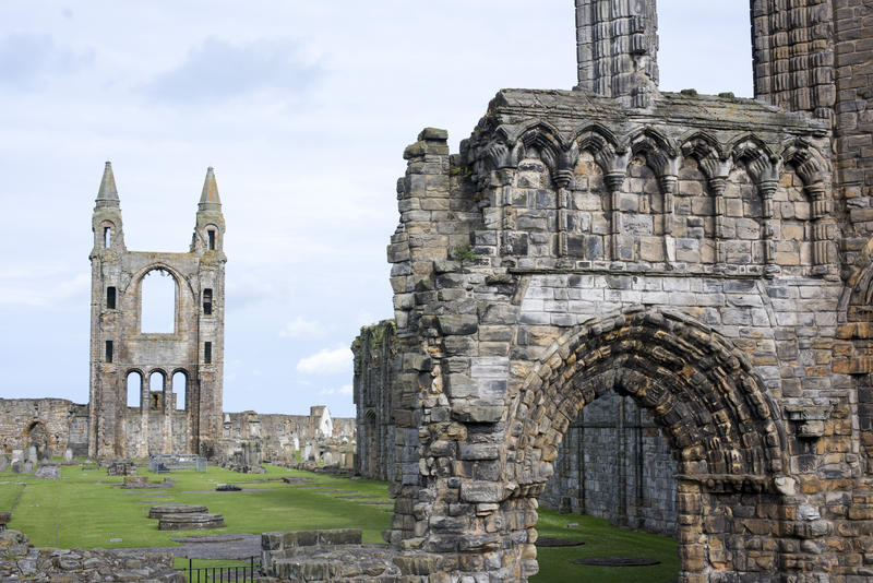 Green grass surrounded by arches and tower at Saint Andrews Cathedral in Scotland, Europe