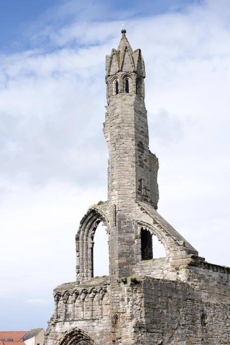 Tall church tower of Saint Andrews Cathedral under scattered clouds with copy space in Scotland, Europe